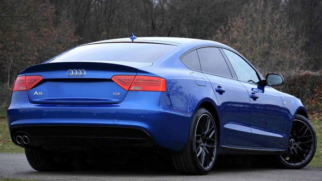 A stylish blue Audi A5 photographed in a peaceful outdoor environment, showcasing modern design and luxury.