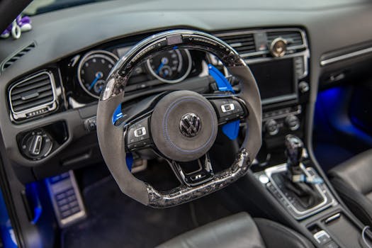 A detailed view of a modern car's custom steering wheel and dashboard, showcasing elegance.